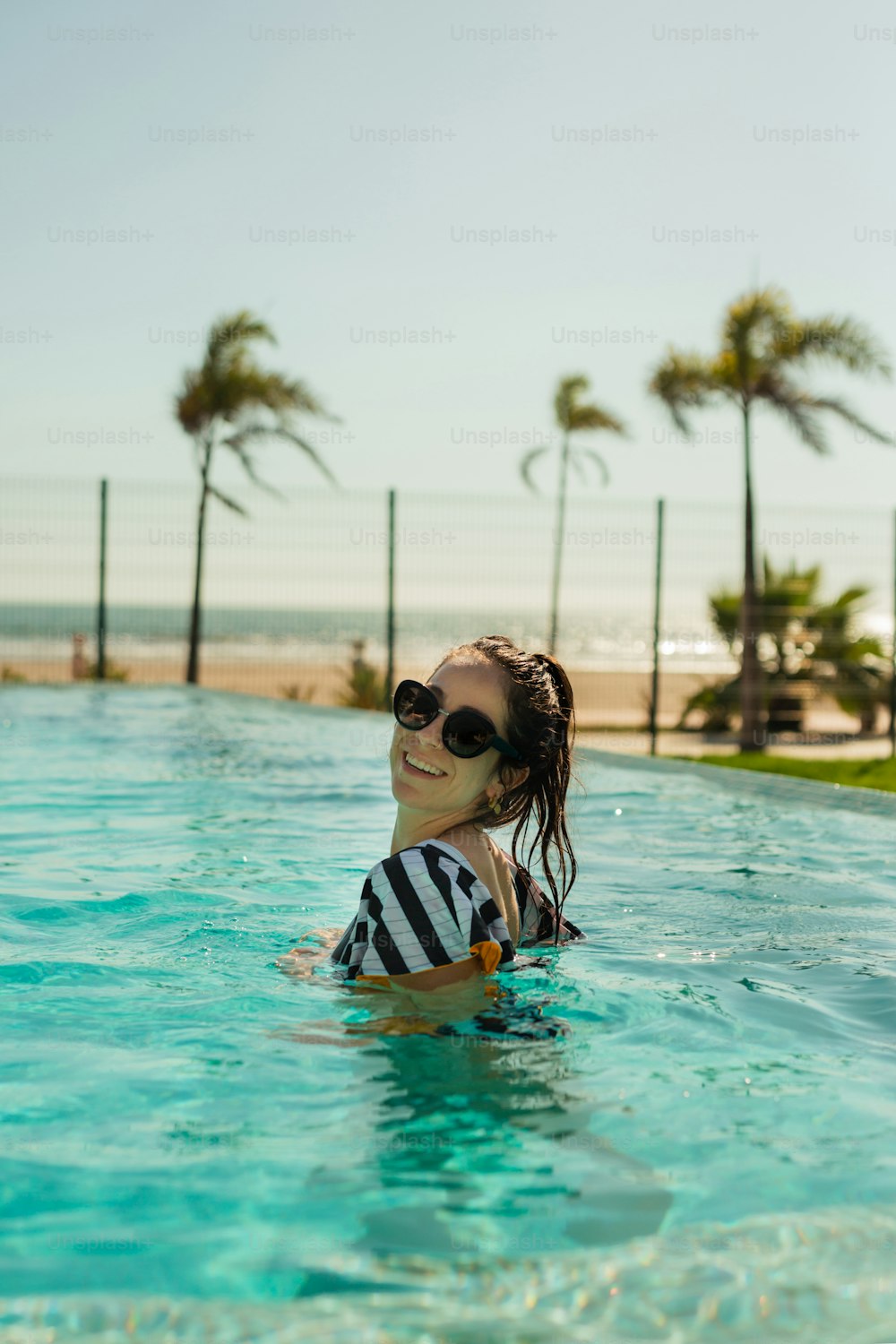 una donna che porta occhiali da sole in una piscina