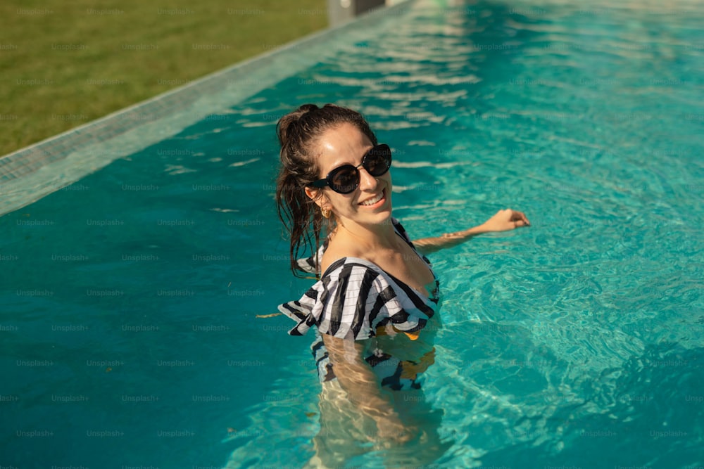 Una mujer con una camiseta de rayas blancas y negras en una piscina
