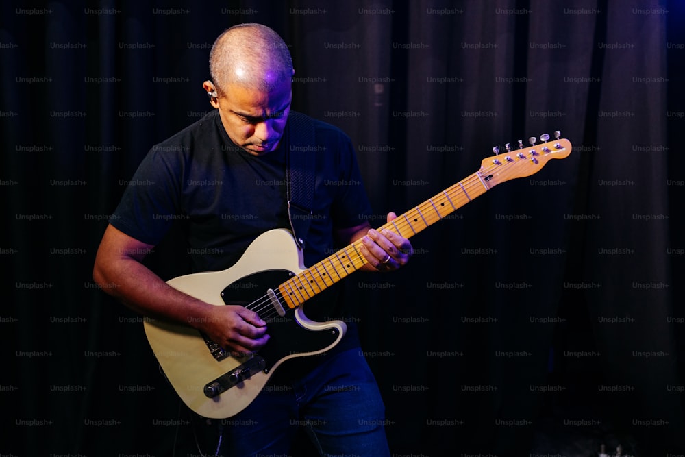 a man playing a guitar in a dark room