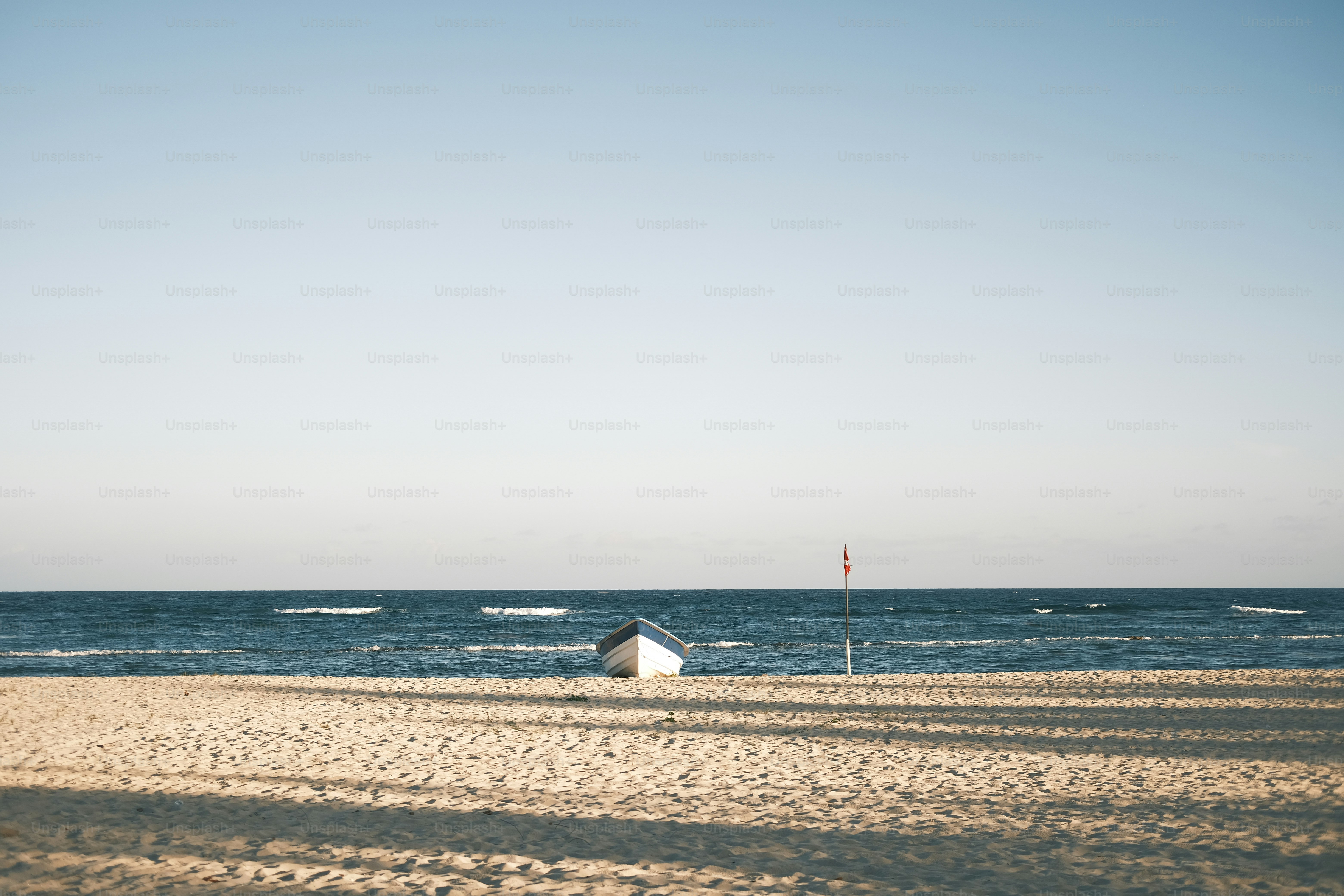 a boat sitting on top of a sandy beach
