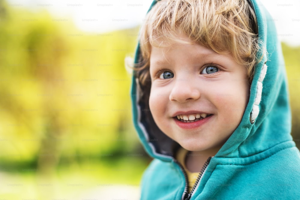 A happy toddler boy outside in spring nature. Close up. Copy space.