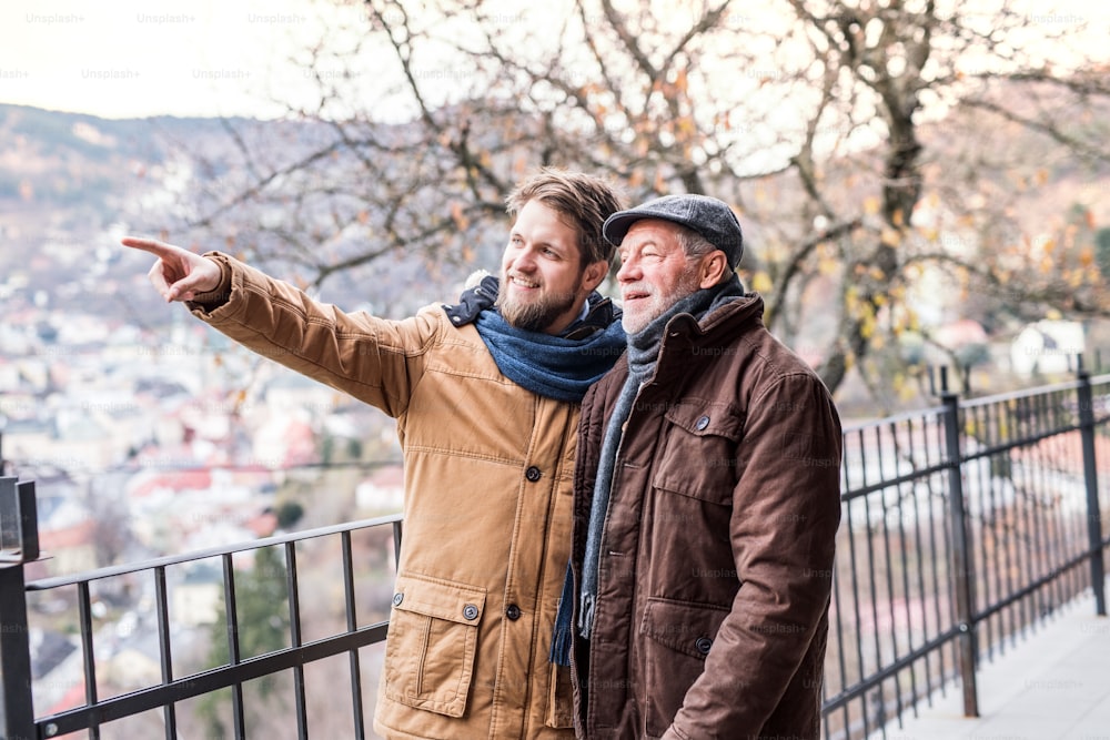 Senior father and his young son on a walk in town.