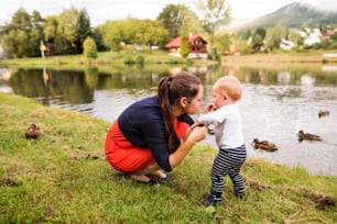 Cute little boy making first steps in nature. mother and son spending time in nature. Summer time.