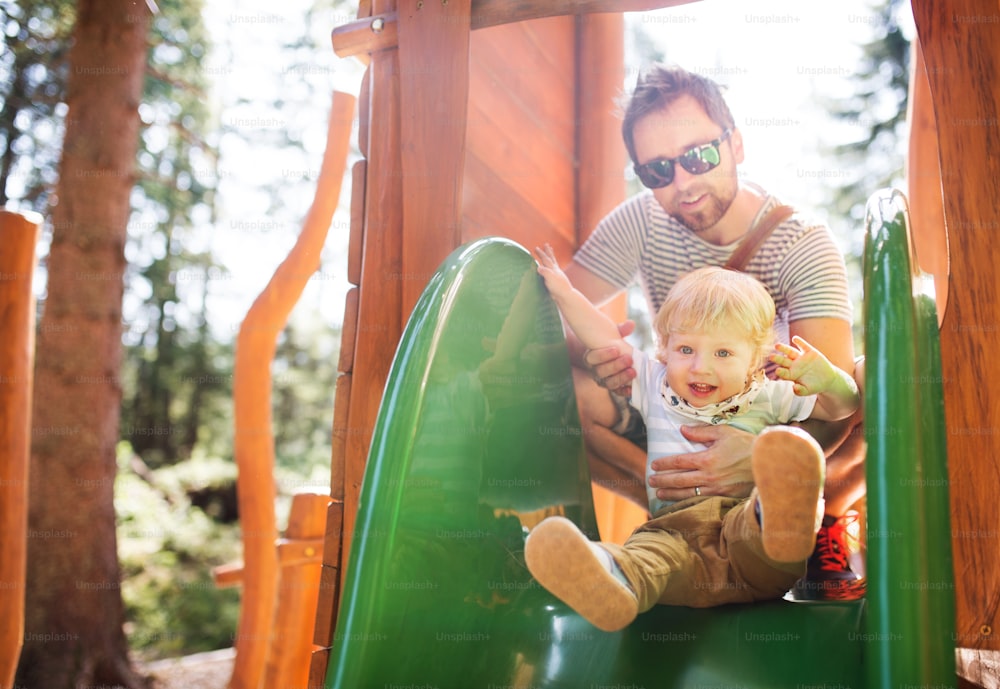 Young father with cute little boy on the playground.