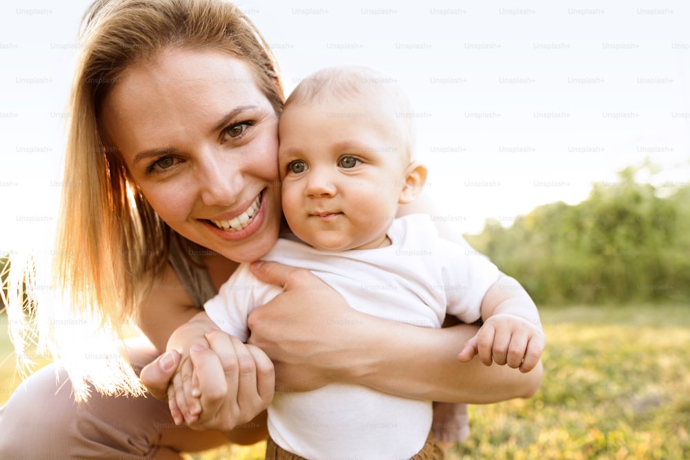 Beautiful young mother with her baby son. First steps.