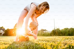 Cute baby boy with his mother outside in the garden.