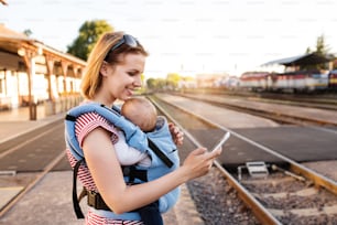 Jeune mère voyageant avec un petit garçon en train. Une femme avec un smartphone et son fils à la gare.