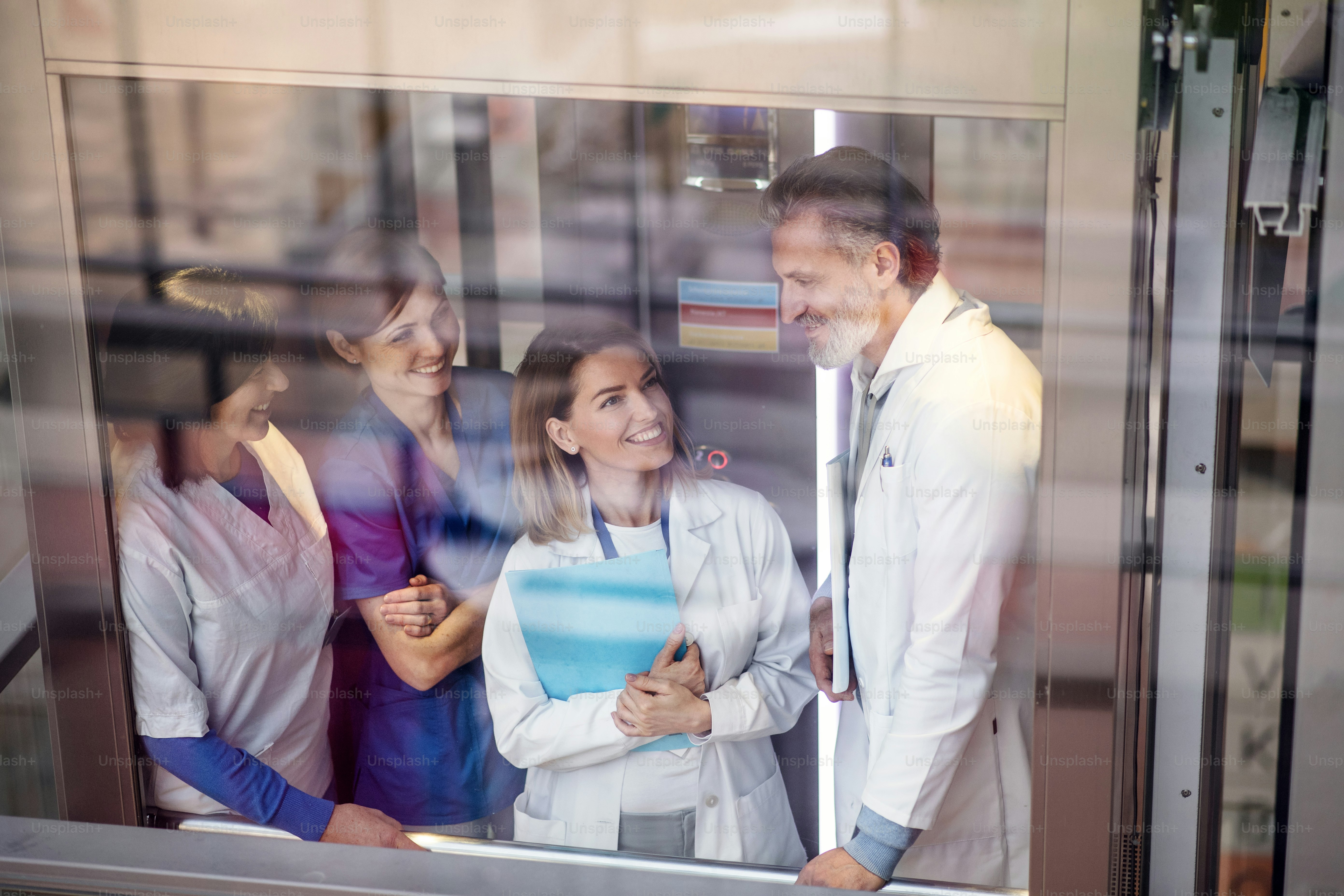 A group of doctors with laptop on conference, medical team discussing ...