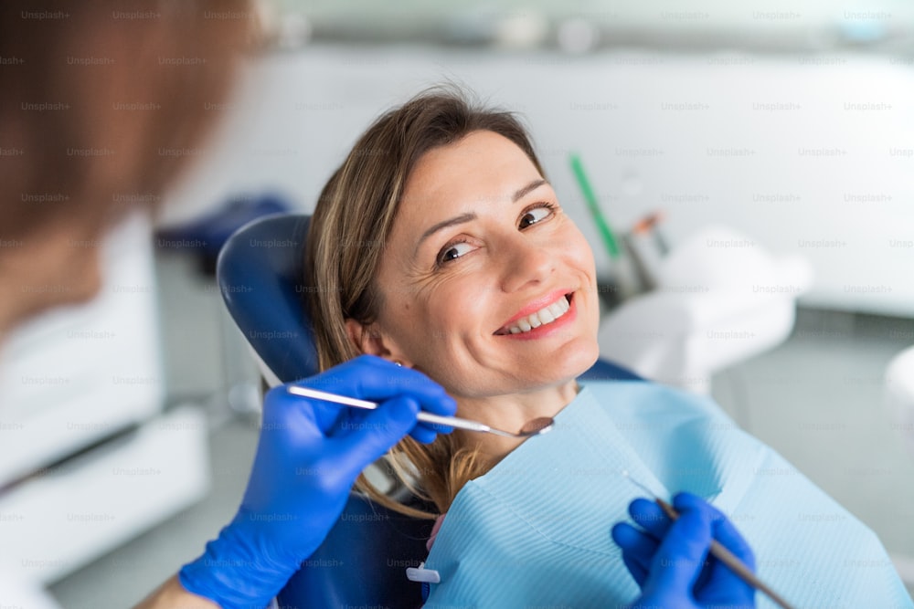 Una donna ha un check-up dentale annuale in chirurgia dentistica.