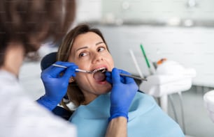 A woman has an annual dental check-up in dentist surgery.