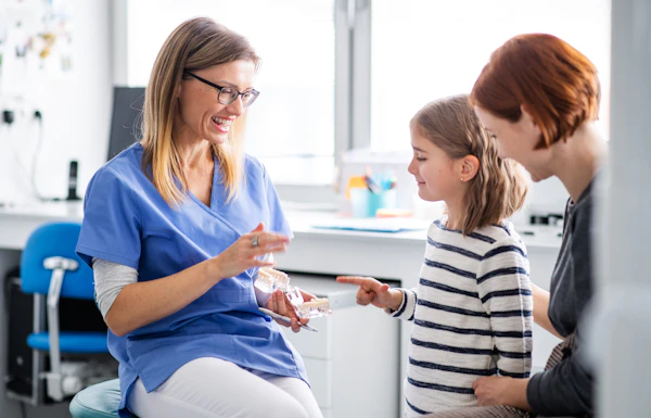 Little girl happily visiting the dentist with mother