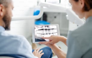 Eine Rückansicht von Mensch und Zahnarzt in der Zahnarztpraxis, jährliche Untersuchung.