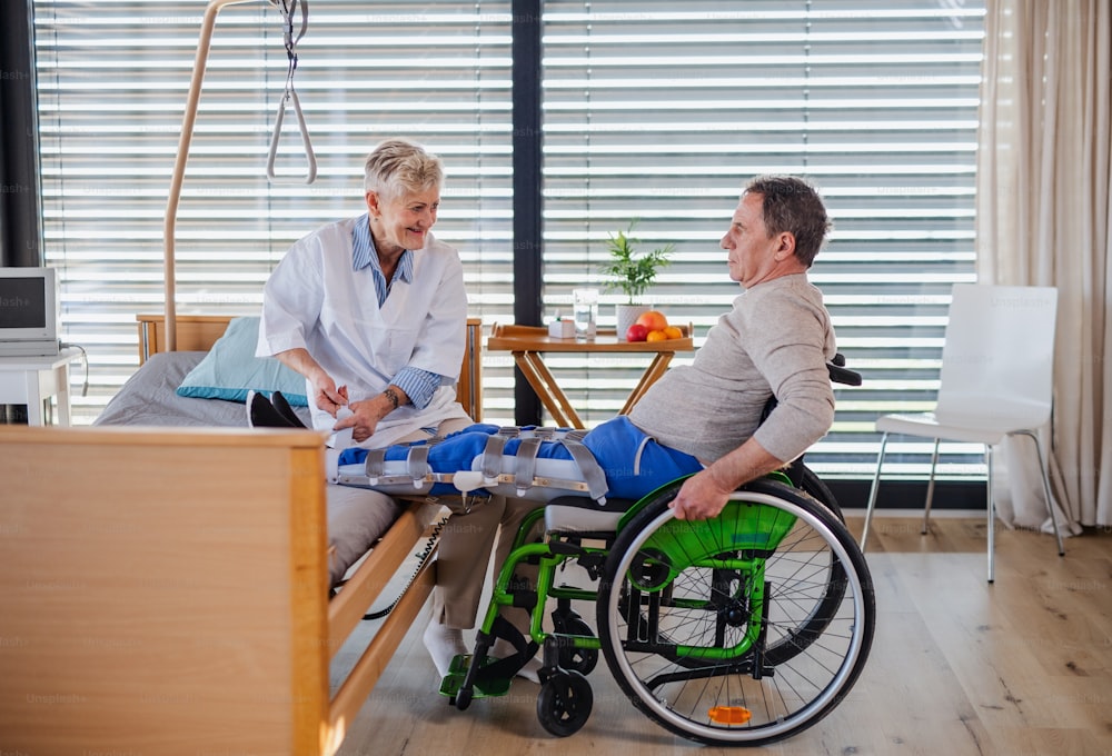 医療従事者と男性が病院の高齢患者を麻痺させ、装具を適用した。