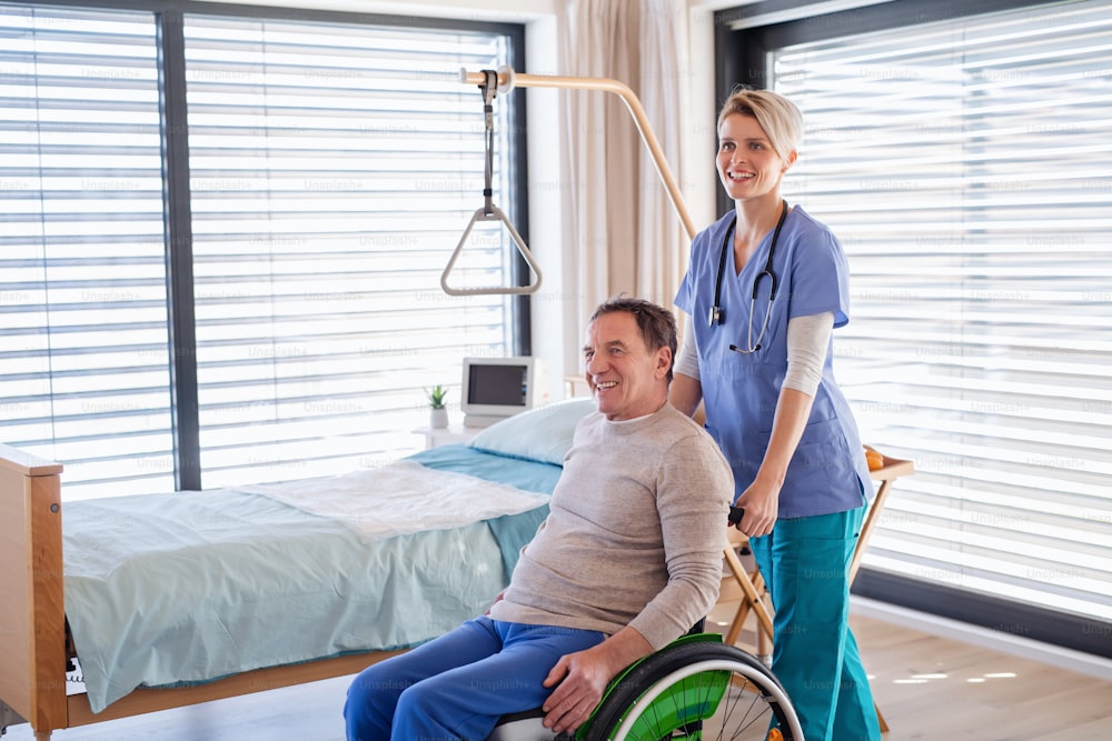 Un travailleur de la santé et un patient âgé en fauteuil roulant à l’hôpital ou à la maison.