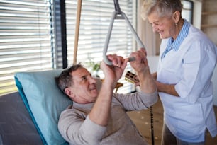 병원에서 마비된 노인 환자를 돕는 의료 종사자.
