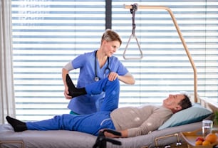 A healthcare worker and senior patient in hospital, physiotherapy concept.