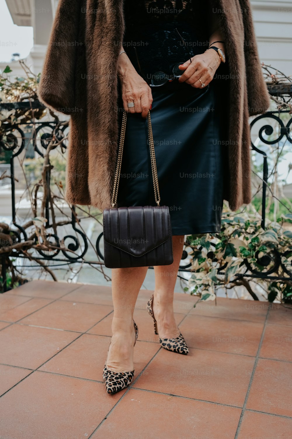 a woman in a black dress and a fur coat