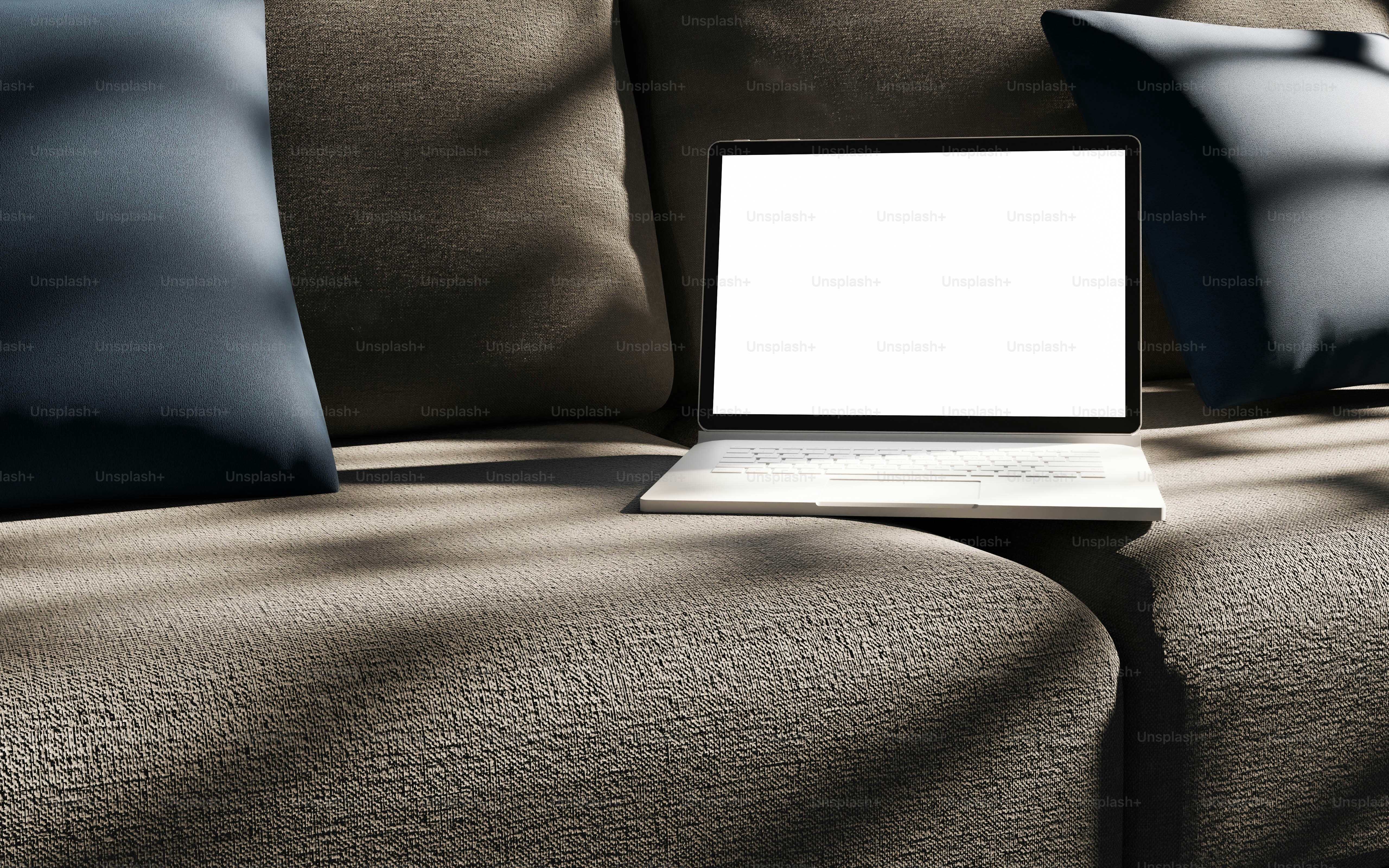 A laptop computer sitting on top of a couch photo – Technology Image on ...