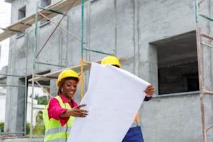 a woman in a hard hat holding a large sheet of paper