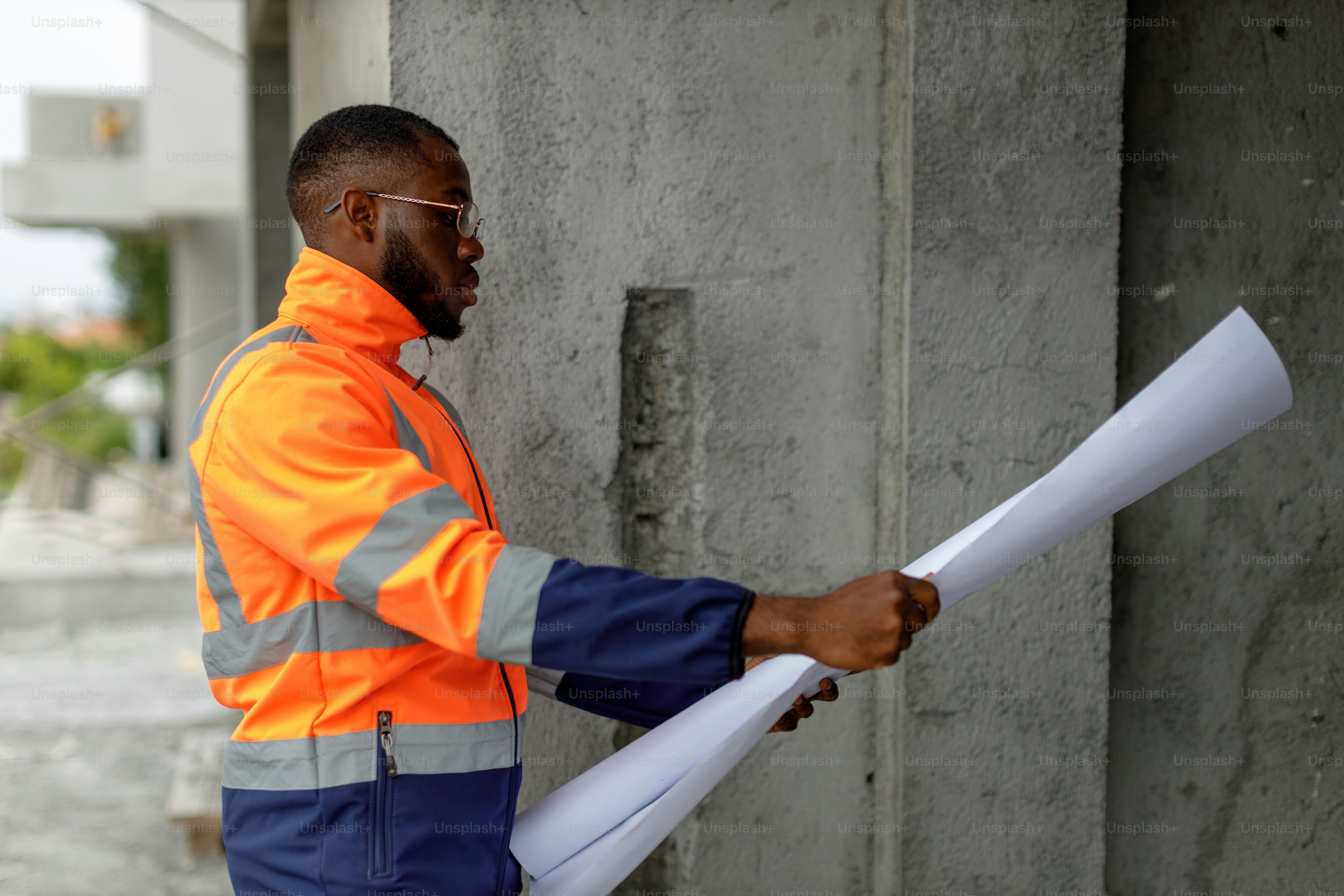 Ein Mann in einer orange-blauen Jacke, der ein Stück Papier hält