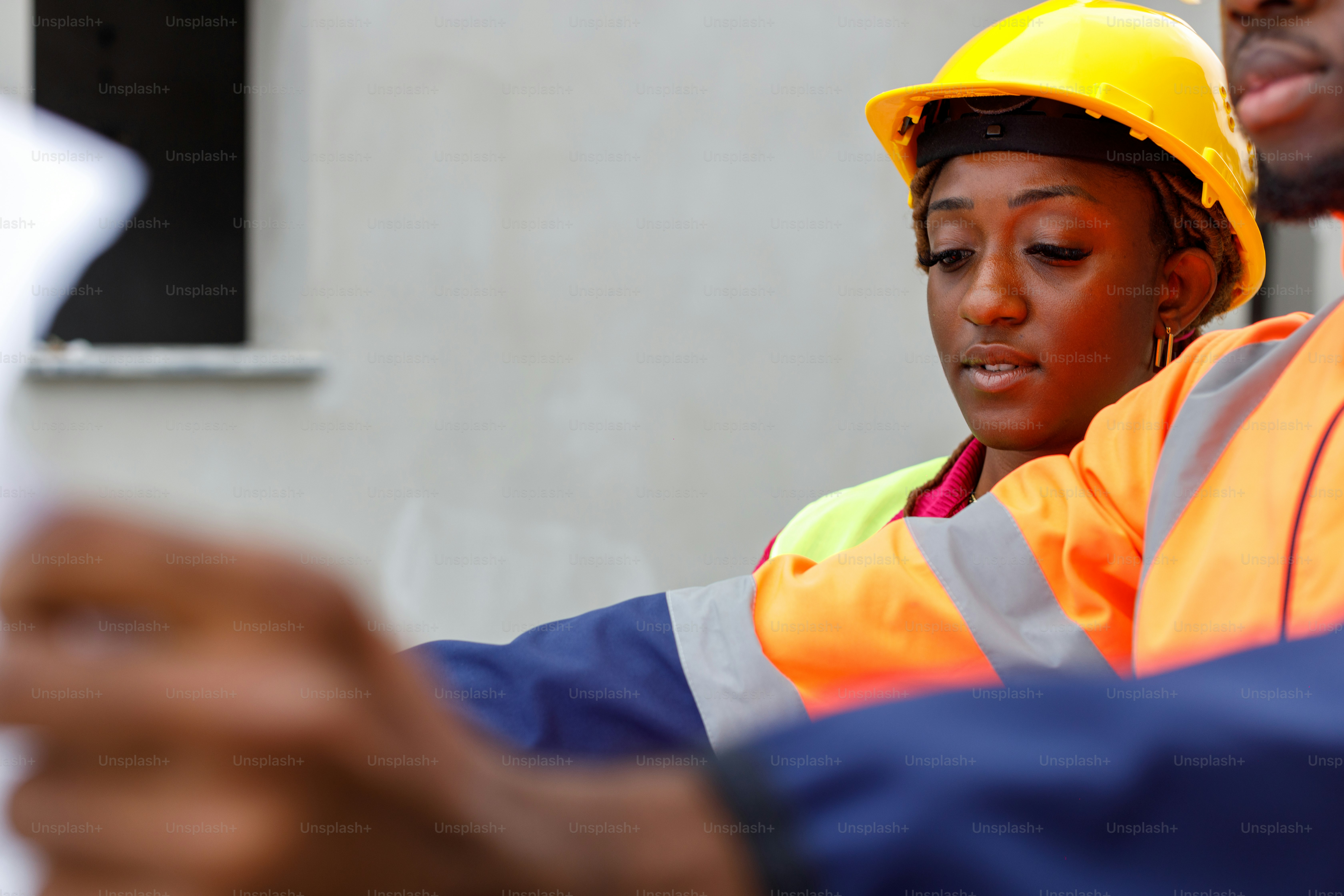 Ein Mann und eine Frau in Sicherheitsausrüstung betrachten ein Blatt Papier