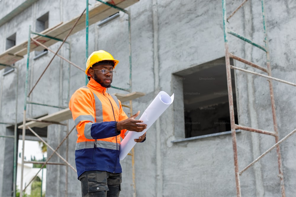 a man in a hard hat and safety vest holding a blueprint