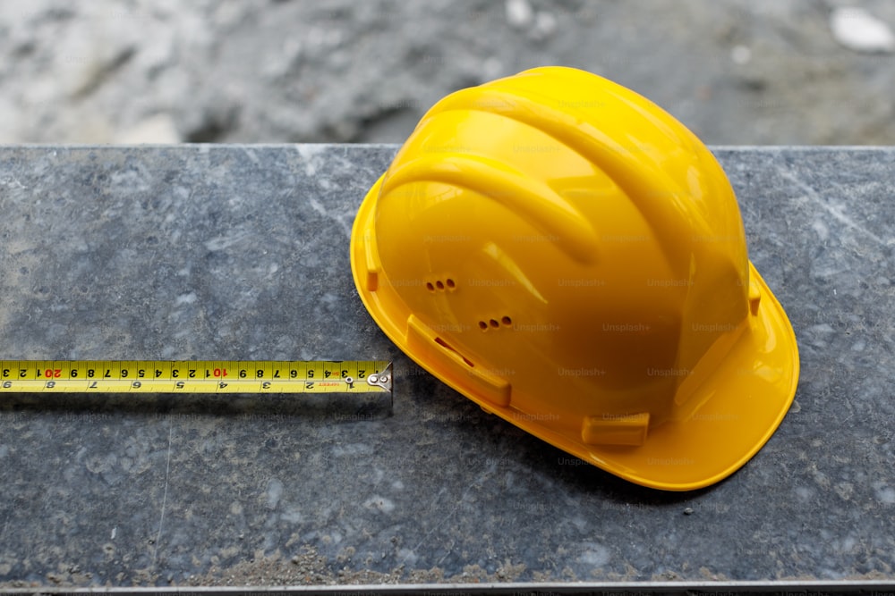 a yellow hard hat next to a ruler