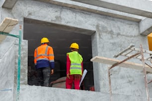 a couple of men standing on top of a building under construction