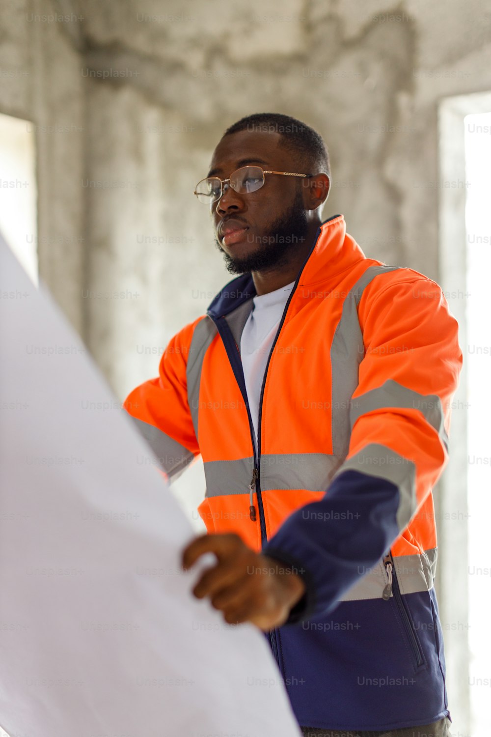 a man in an orange safety jacket holding a piece of paper