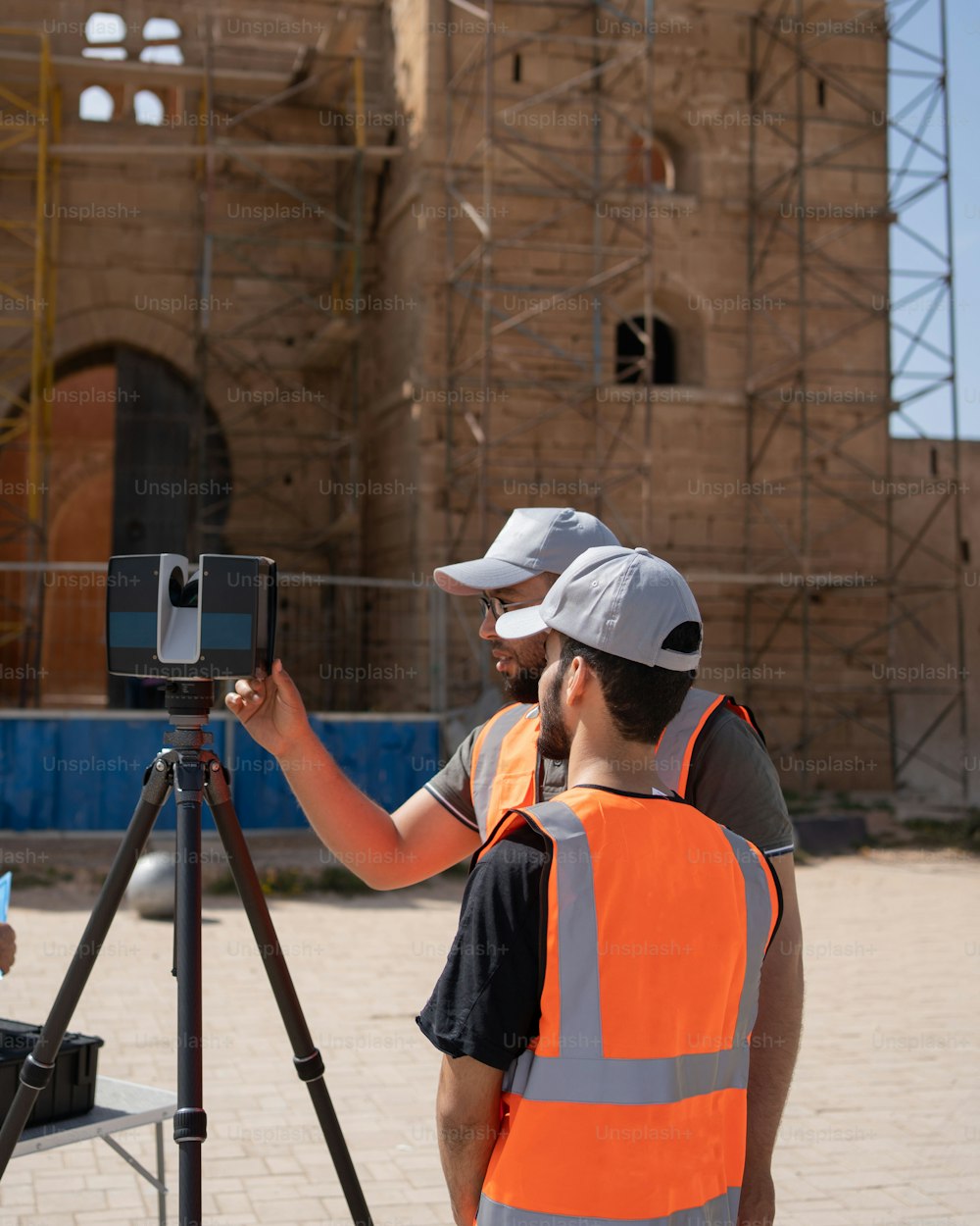 two construction workers standing in front of a building under construction