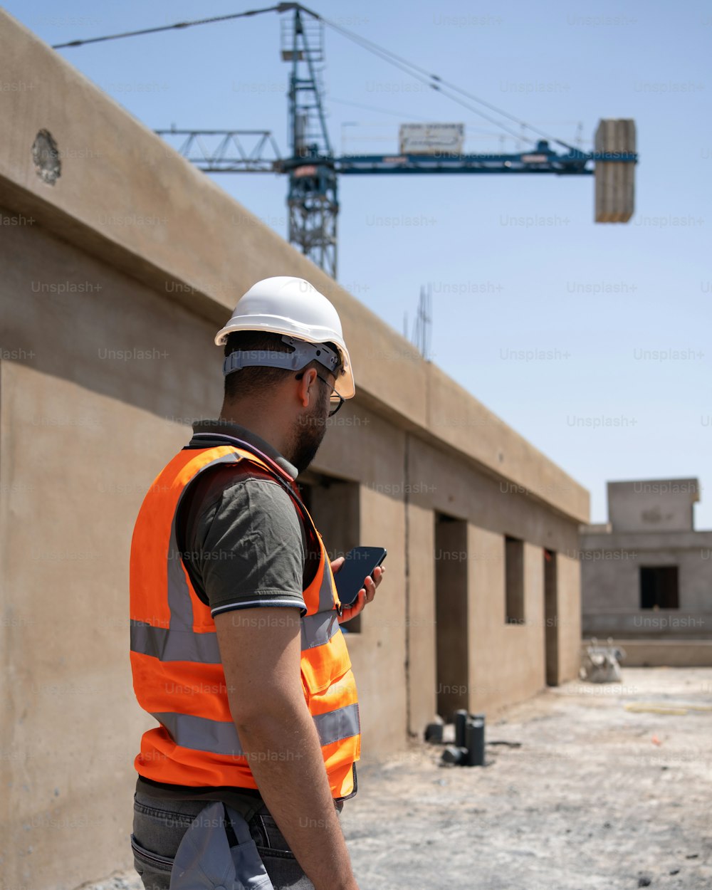 um trabalhador da construção civil olhando para seu celular
