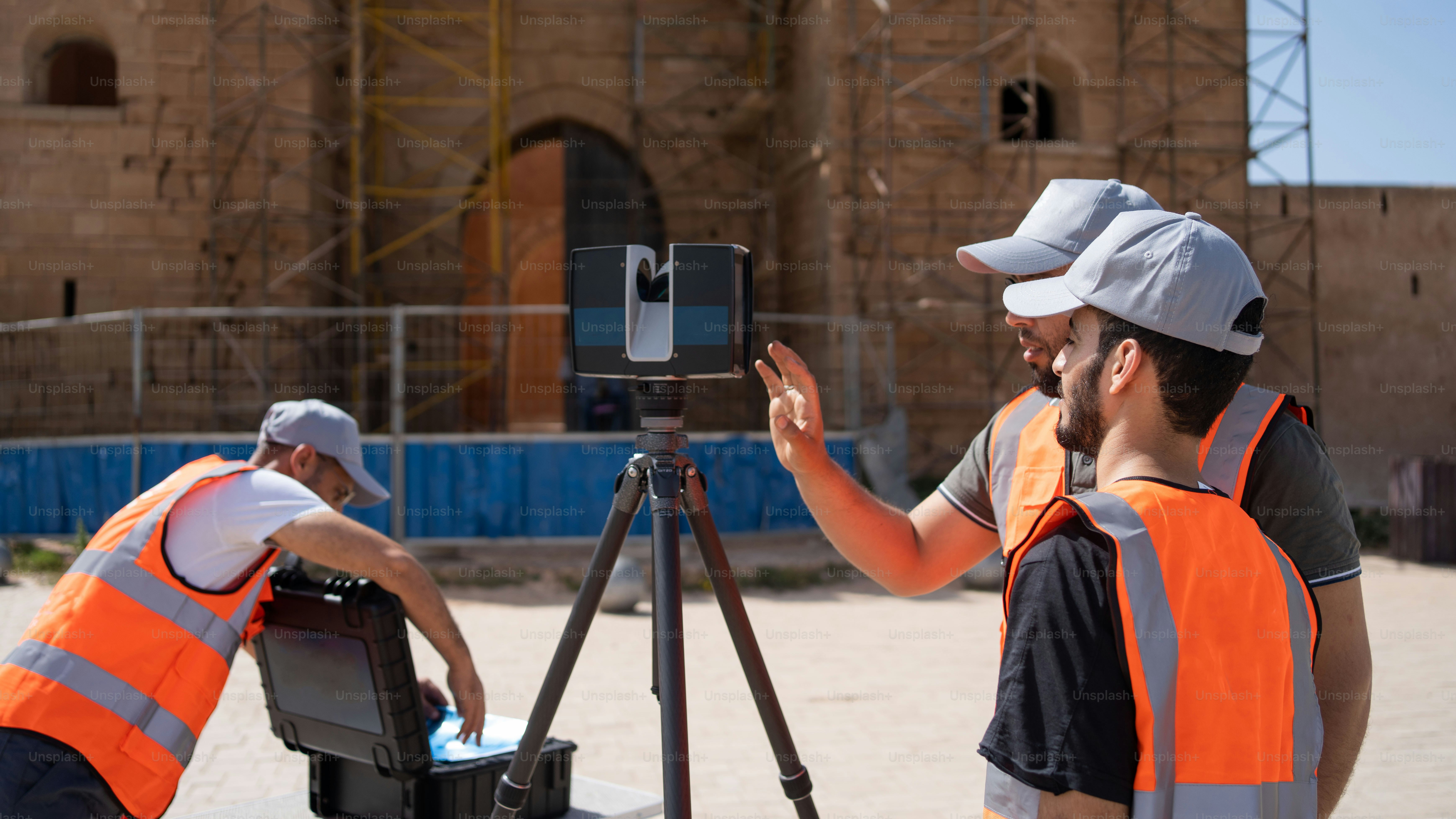 a couple of men standing next to a camera