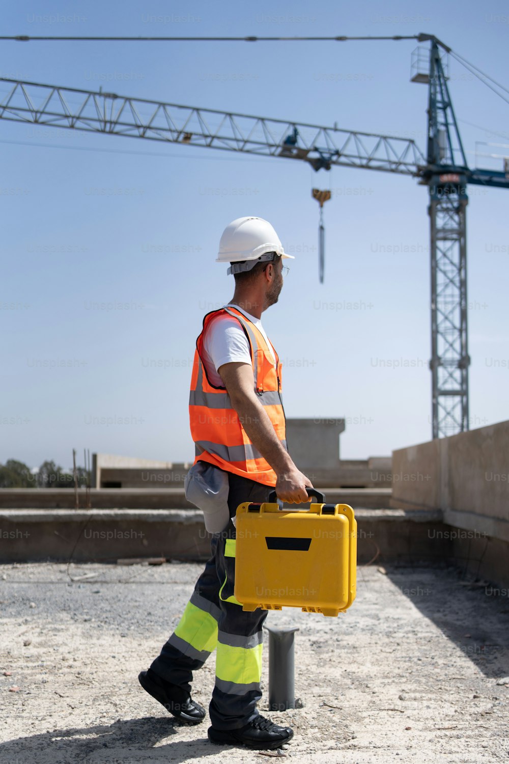 a construction worker carrying a yellow briefcase