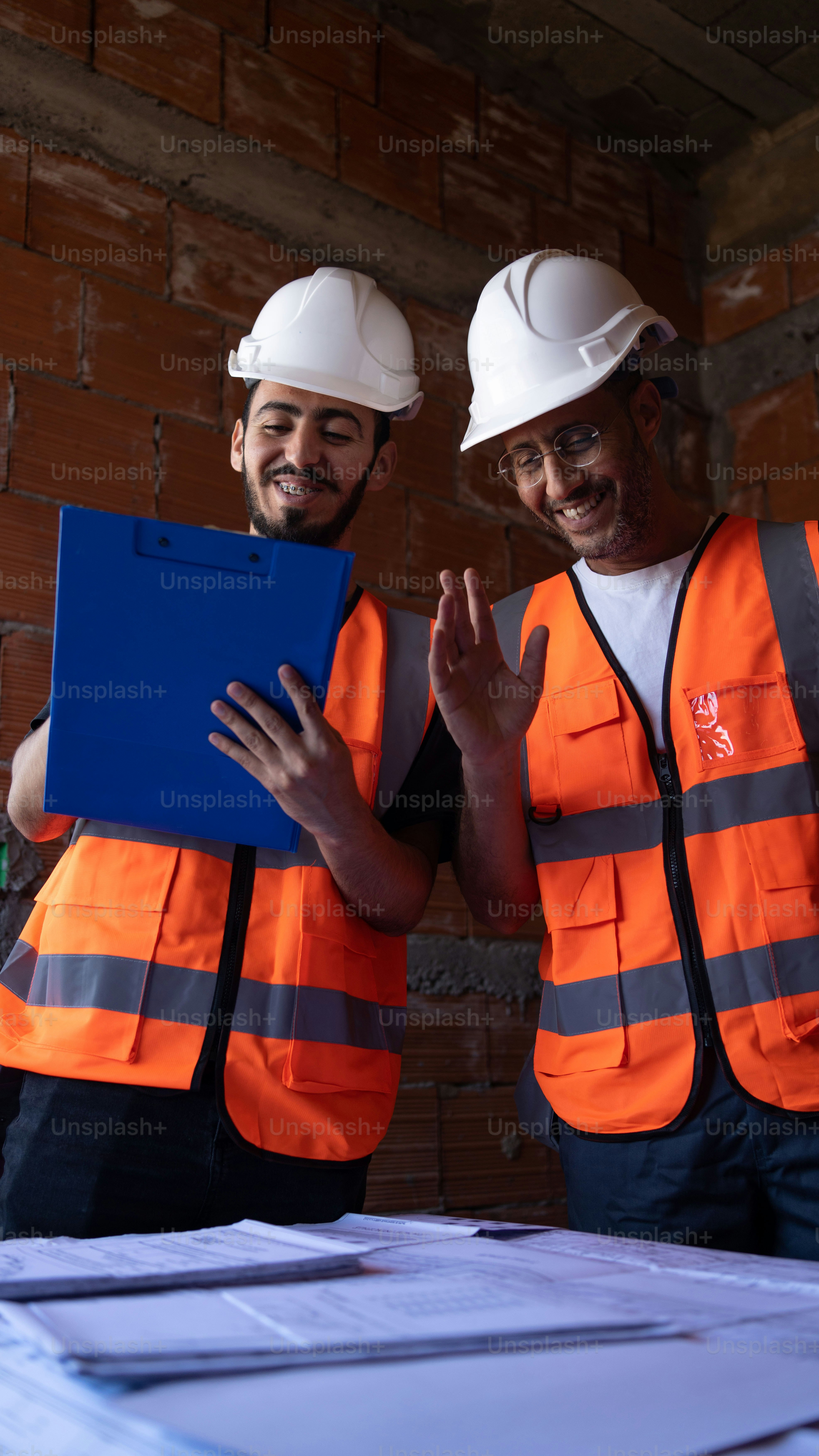 A couple of men standing next to each other photo – Engineer Image on ...