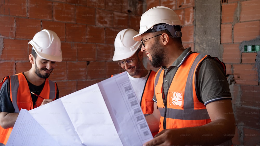 three men in hardhats looking at a piece of paper