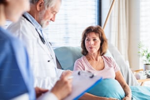 Doctor and nurse examining a woman patient in hospital. midsection.