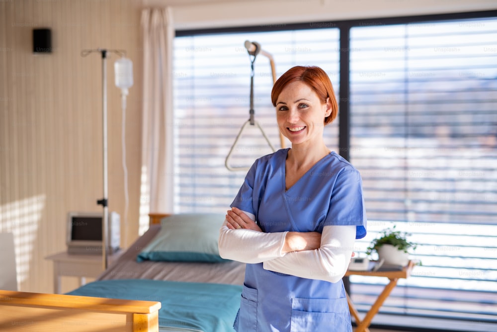 Portrait of female doctor or nurse standing in hospital room. Copy space.