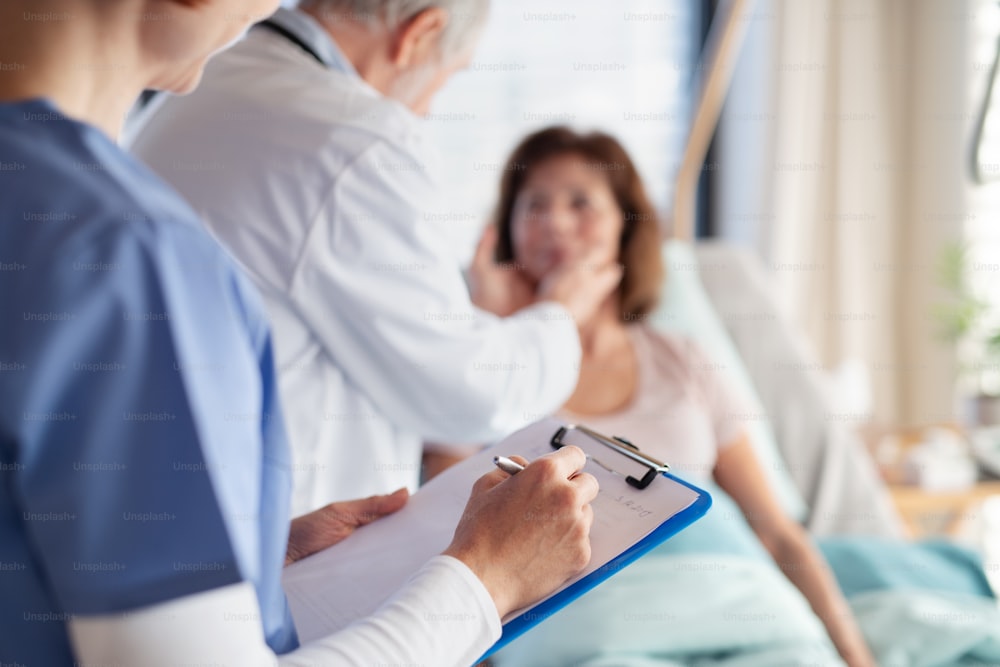 Unrecognizable doctor and nurse examining a woman patient in hospital, midsection.