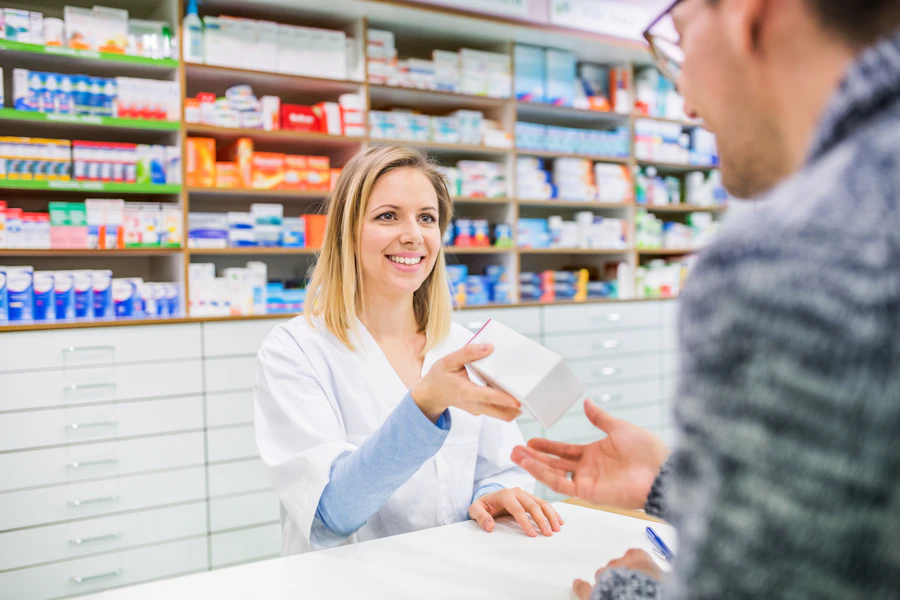 A Velmora pharmacist helping a customer at the pharmacy counter