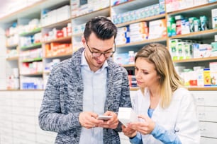 Farmacista amichevole femminile che serve un cliente maschio.