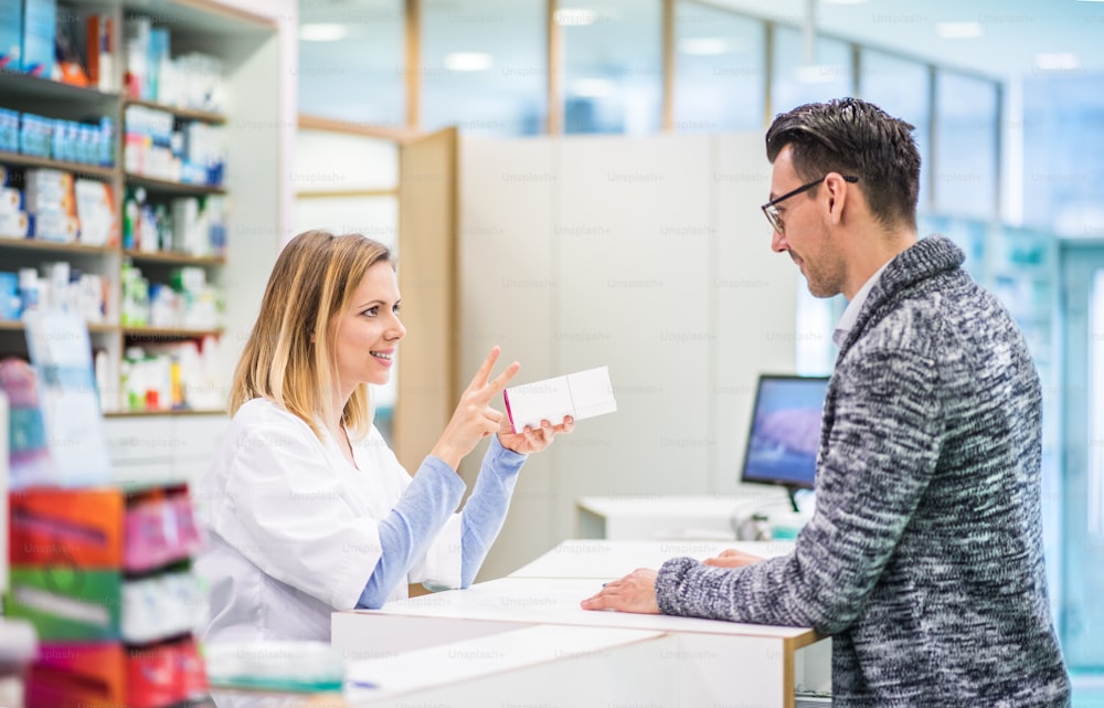 Female friendly pharmacist serving a male customer.
