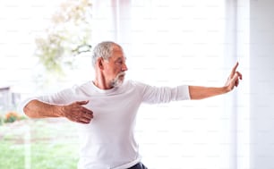 Hombre mayor activo haciendo ejercicio en casa.