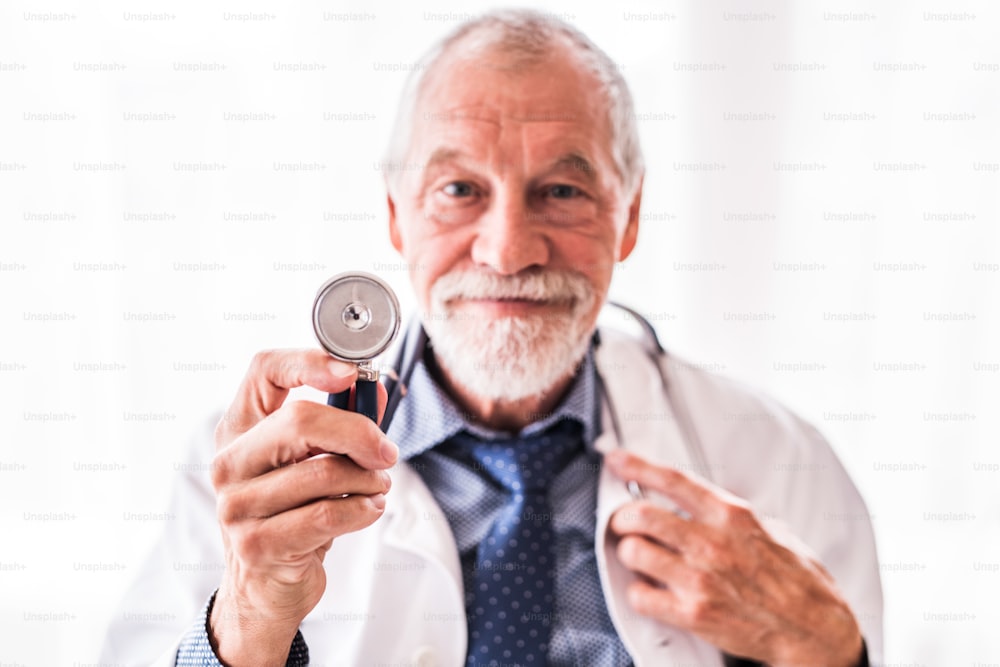 Portrait of a senior doctor with stethoscope in his office.