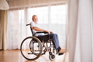家で車椅子に座って幸せに伐採する老人。