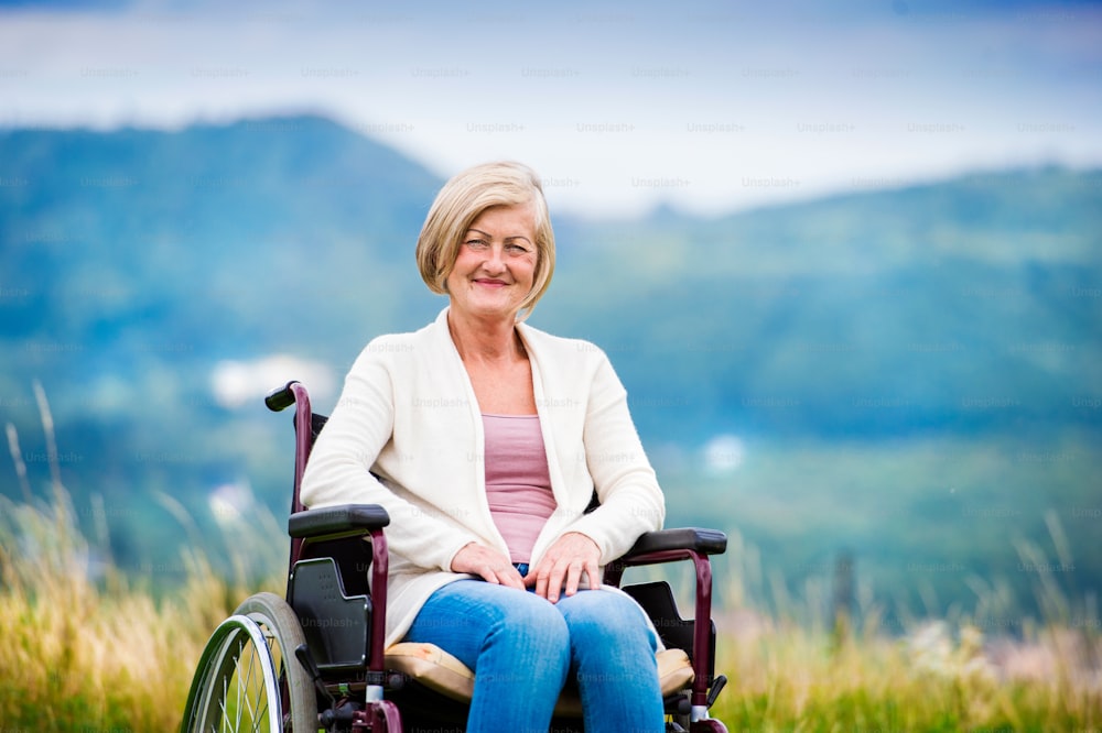 Mujer mayor en silla de ruedas afuera en la naturaleza