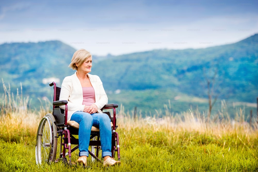 Mujer mayor en silla de ruedas afuera en la naturaleza