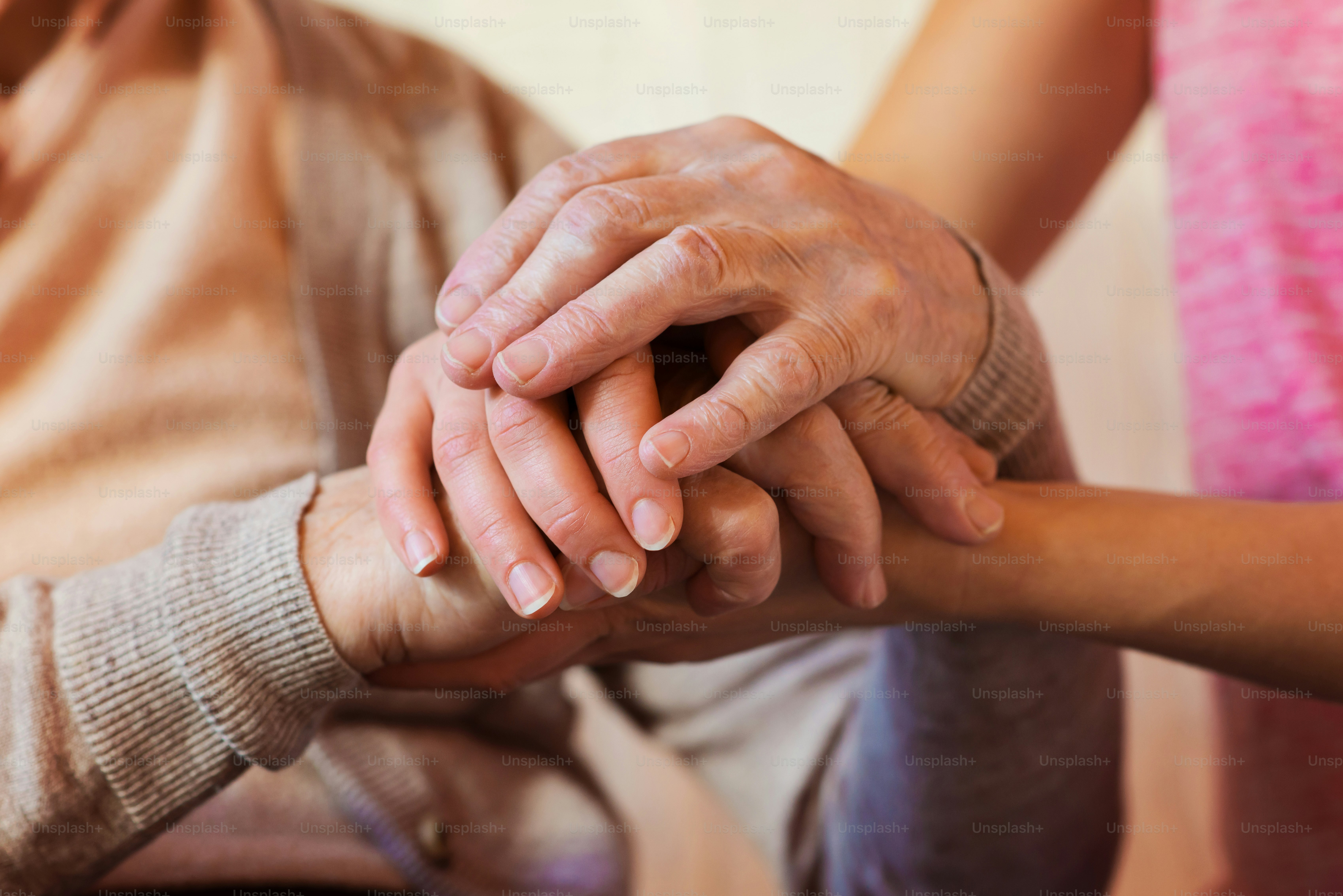 Unrecognizable grandmother and her granddaughter holding hands.