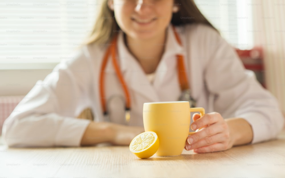 詳細 - 蜂蜜、レモン、お茶の背景に医師の女性
