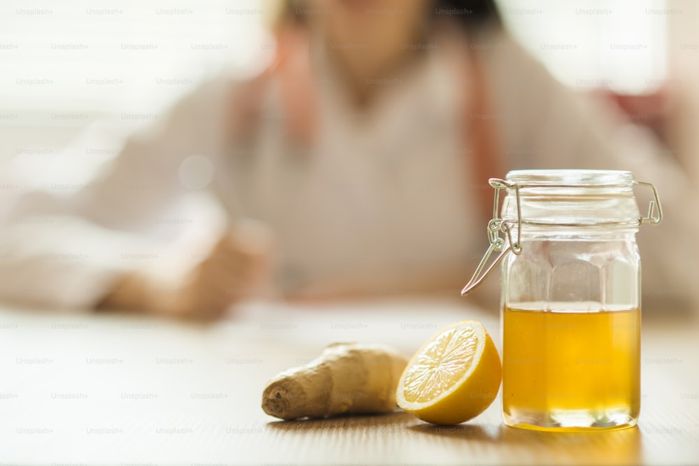 Detalle de miel y limón con doctor mujer de fondo