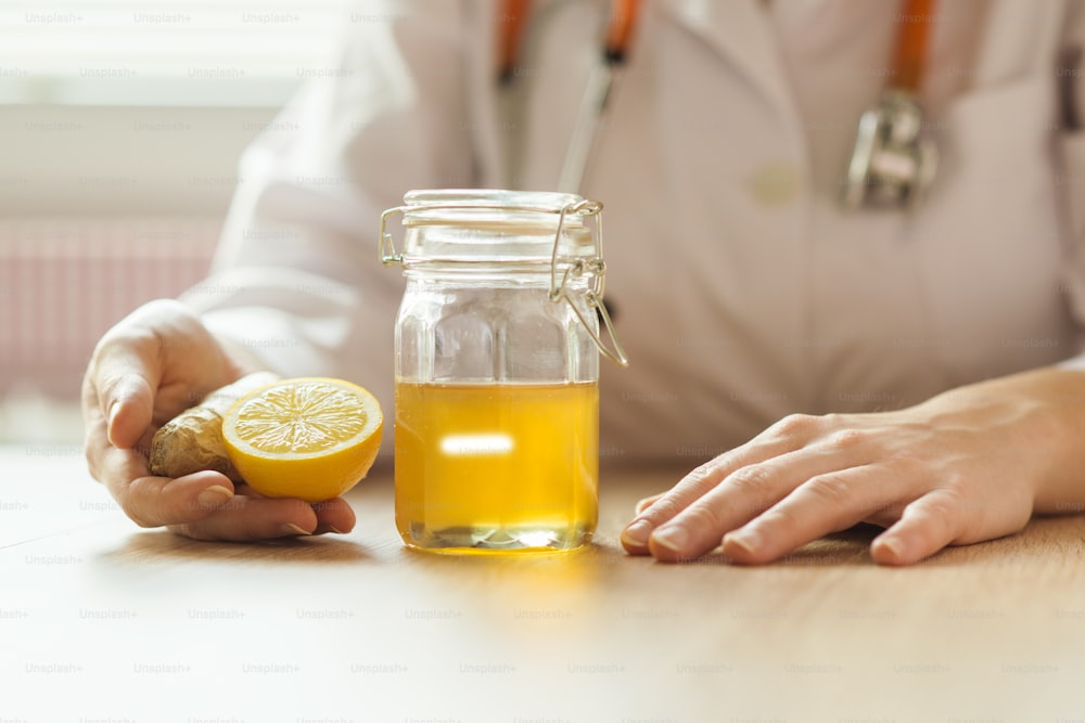Detalle de miel y limón con doctor mujer de fondo